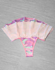 Bikini bottom with pink and purple camouflage pattern on a gray background