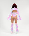 Person wearing a pink and purple camouflage rave outfit with a matching jacket on a white background